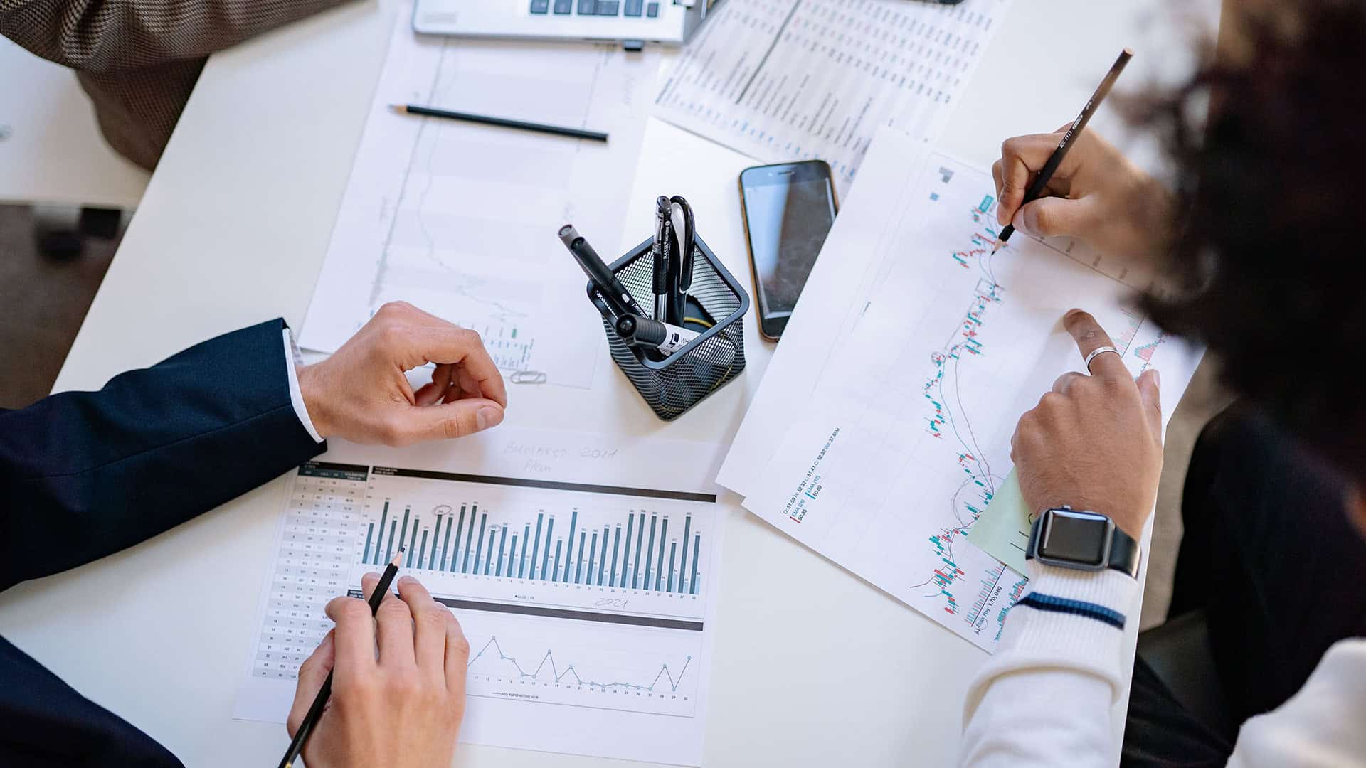 Business professionals analyzing financial charts and graphs at LM Genuine Solutions.