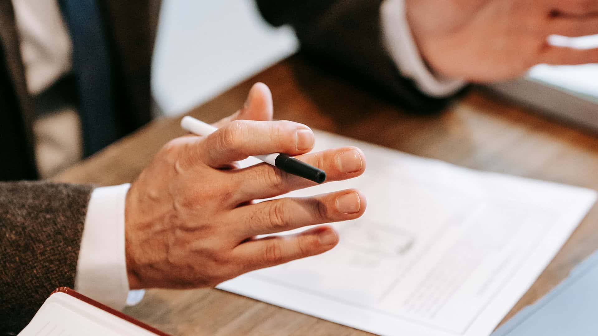 Business professionals discussing documents and using a tablet during a meeting.